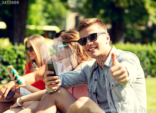 Image of smiling man with smartphone showing thumbs up