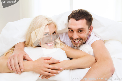 Image of happy couple in bed at home