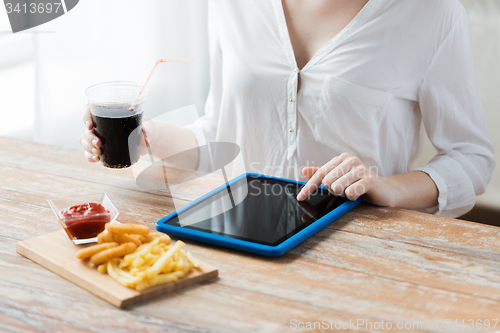 Image of close up of woman with tablet pc and fast food