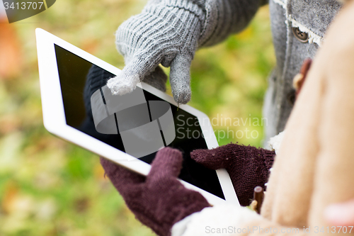 Image of couple hands in gloves with tablet pc outdoors
