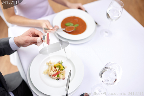 Image of close up of couple eating appetizers at restaurant