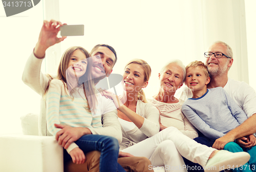 Image of happy family with smartphone at home