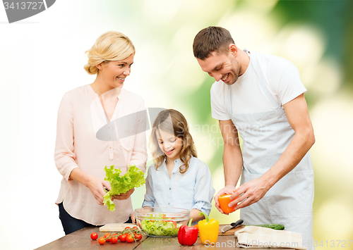 Image of happy family cooking vegetable salad for dinner