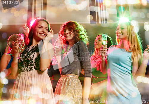 Image of smiling friends with glasses of champagne in club