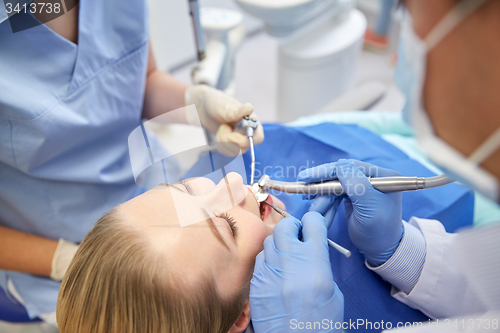 Image of close up of dentist treating female patient teeth