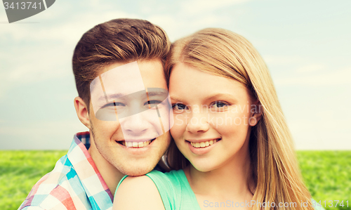 Image of smiling couple hugging over natural background