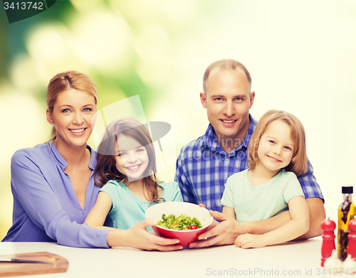 Image of happy family with two kids with salad at home