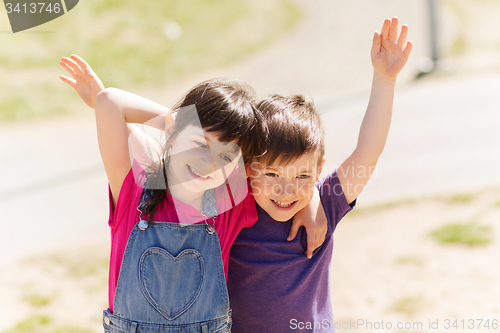 Image of two happy kids hugging outdoors