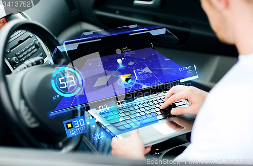 Image of man using navigation on laptop computer in car