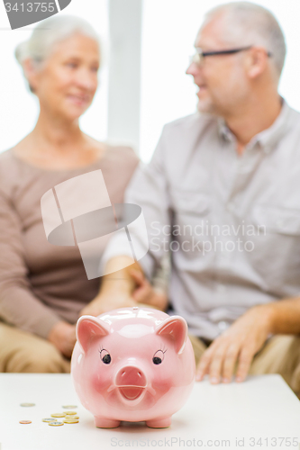 Image of close up of couple with coins and piggy bank