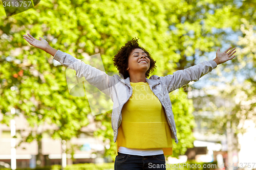 Image of happy african american young woman in summer park