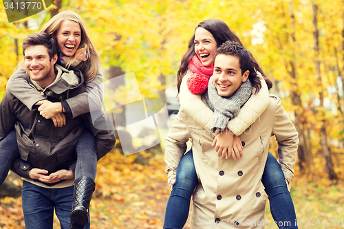 Image of smiling friends having fun in autumn park