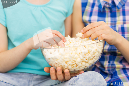 Image of close up of kids with popcorn bowl eating