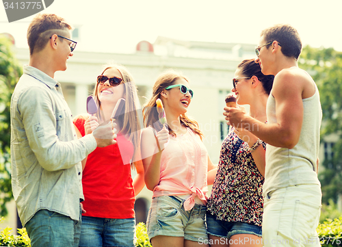 Image of group of smiling friends with ice cream outdoors