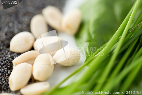 Image of close up of peeled peanuts, greens and seeds