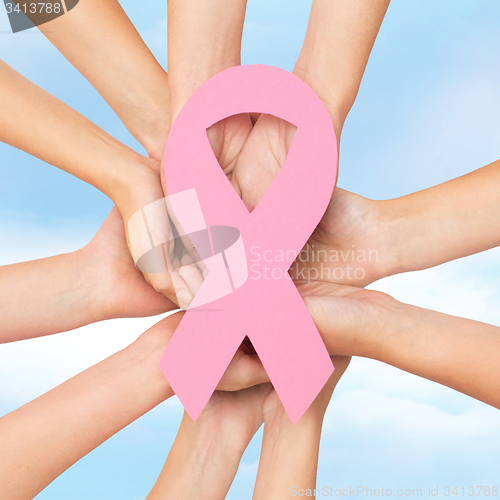 Image of close up of hands with cancer awareness symbol