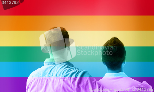 Image of close up of male gay couple over rainbow flag