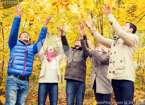 Image of group of smiling men and women in autumn park