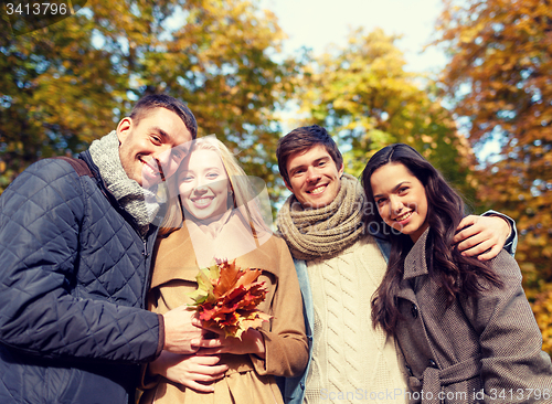 Image of group of smiling men and women in autumn park