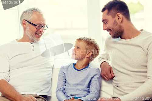 Image of smiling family sitting on couch home