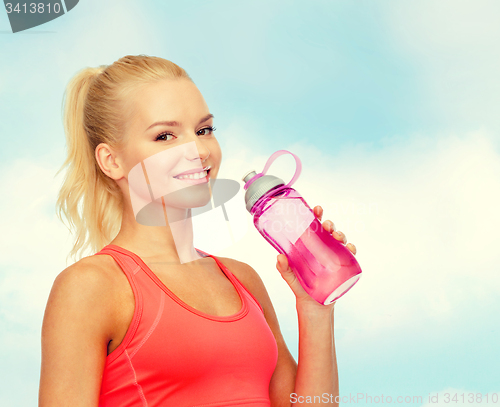 Image of smiling sporty woman with water bottle