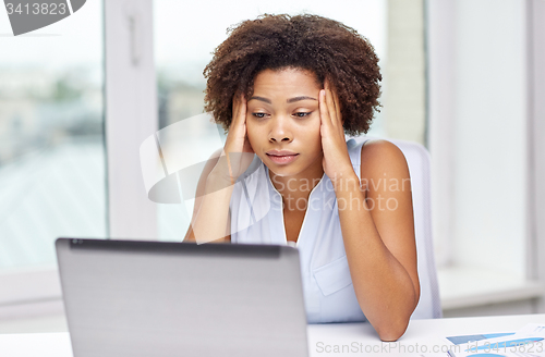 Image of african woman with laptop at office