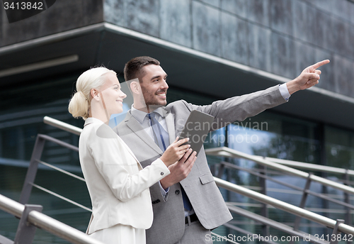 Image of smiling businessmen with tablet pc outdoors