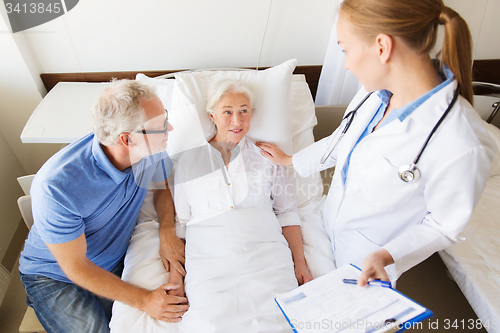 Image of senior woman and doctor with clipboard at hospital