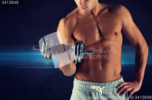 Image of close up of young man with dumbbell flexing biceps