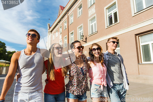 Image of group of smiling friends walking in city