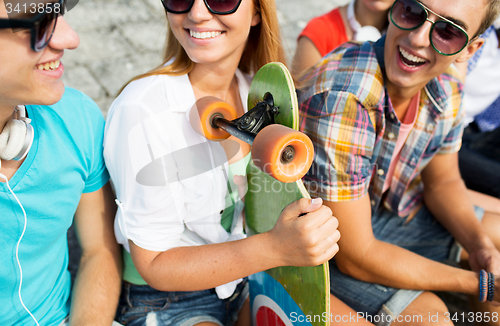 Image of close up of happy friends with longboard on street