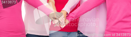 Image of close up of women in pink shirts with hands on top