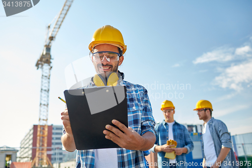 Image of builder in hardhat with clipboard at construction