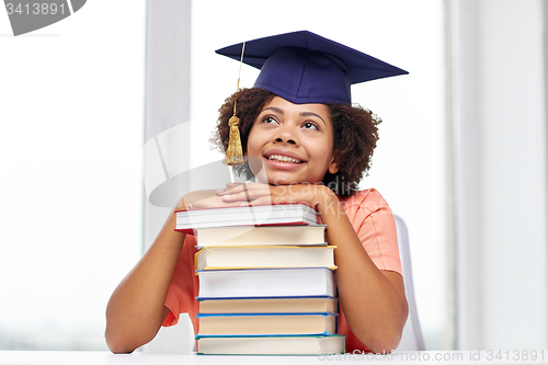 Image of happy african bachelor girl with books at home