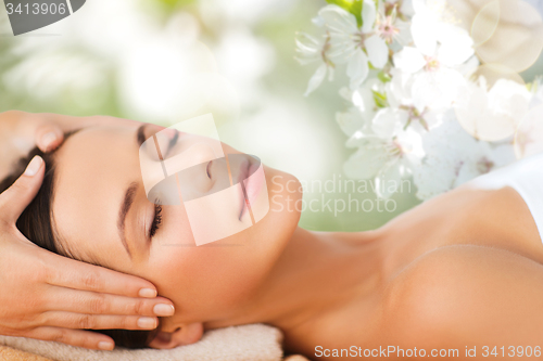 Image of beautiful woman in spa salon having facial massage