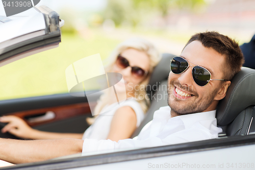 Image of happy man and woman driving in cabriolet car