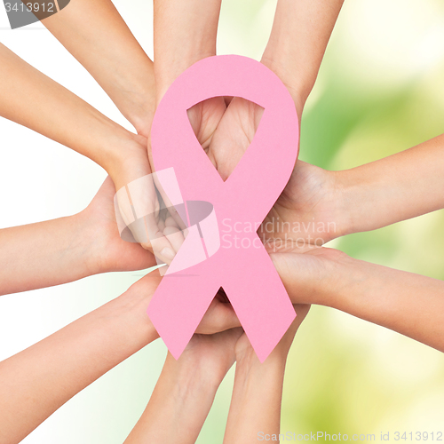 Image of close up of hands with cancer awareness symbol