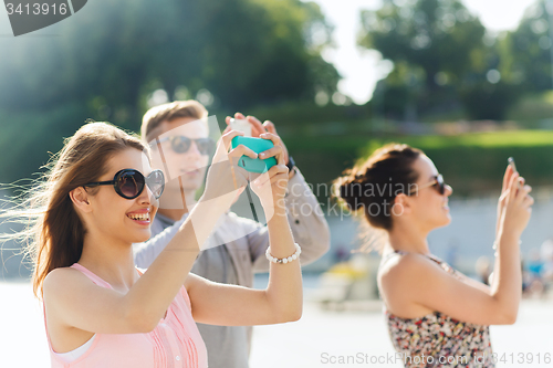 Image of smiling friends with smartphone taking picture