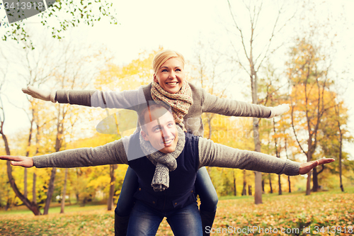 Image of smiling couple having fun in autumn park