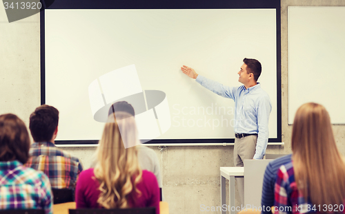 Image of group of students and smiling teacher in classroom