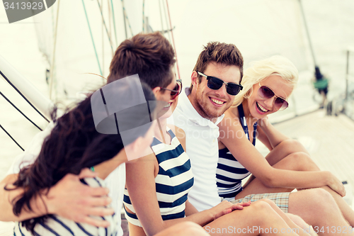 Image of smiling friends sitting on yacht deck