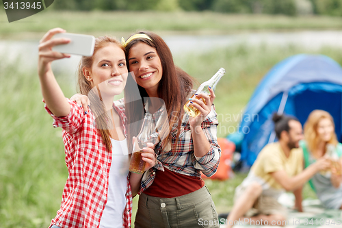 Image of happy women taking selfie by smartphone at camping