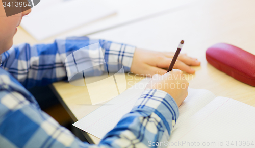 Image of close up of schoolboy writing test at school