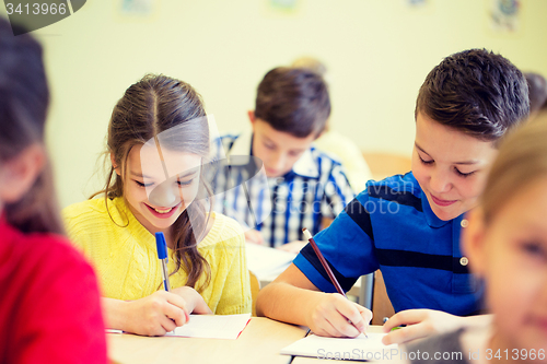 Image of group of school kids writing test in classroom