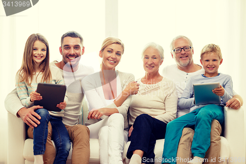 Image of smiling family with tablet pc at home