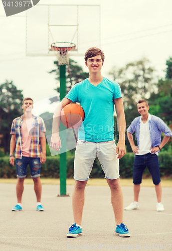 Image of group of smiling teenagers playing basketball