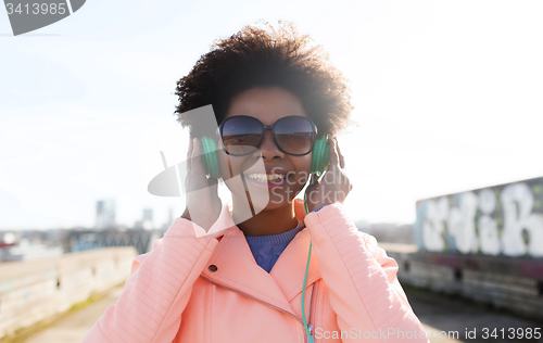 Image of happy young woman in headphones listening to music