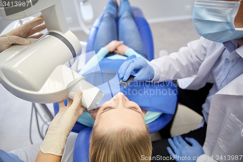 Image of dentist and patient with dental x-ray machine