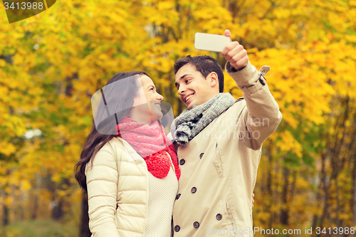 Image of smiling couple hugging in autumn park