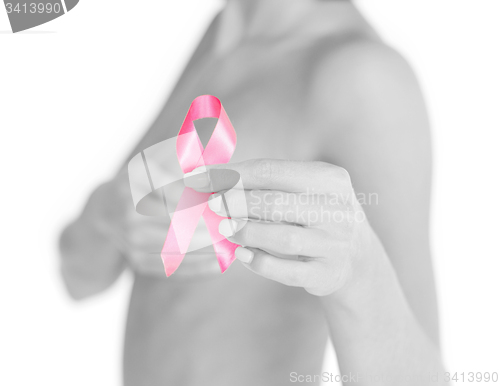 Image of hand holding pink breast cancer awareness ribbon